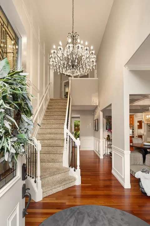 Two-story foyer with chandelier, curved staircase, and hardwood floors