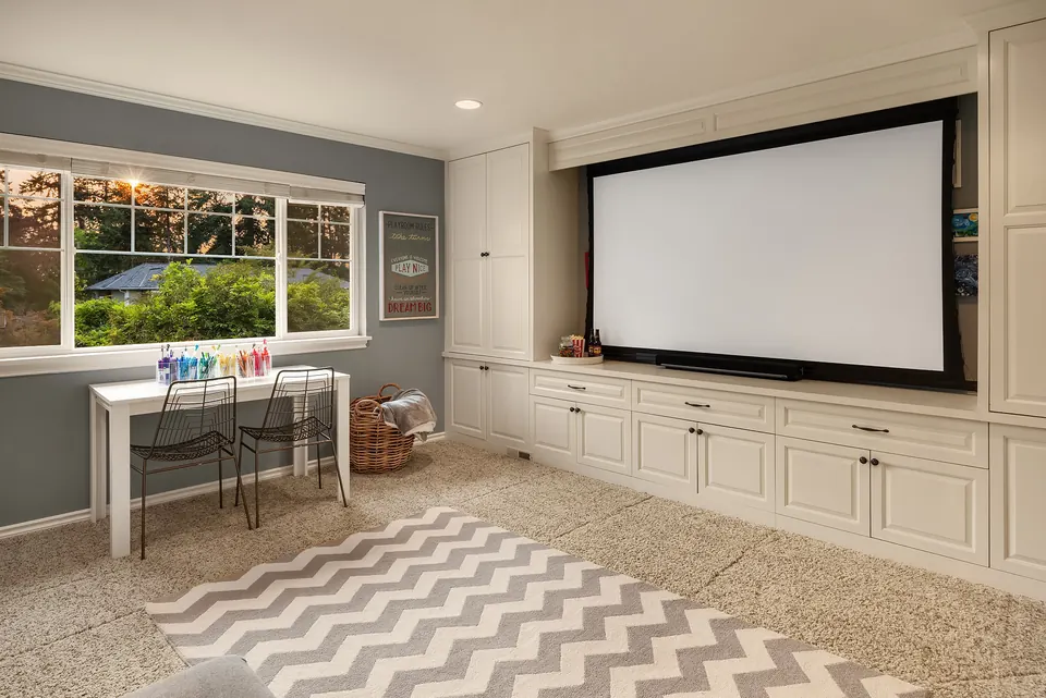 Bonus room with projection screen, built-in cabinetry, and work desk