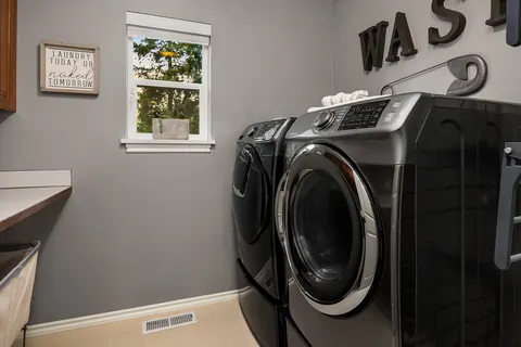 Upstairs laundry room with side-by-side washer and dryer