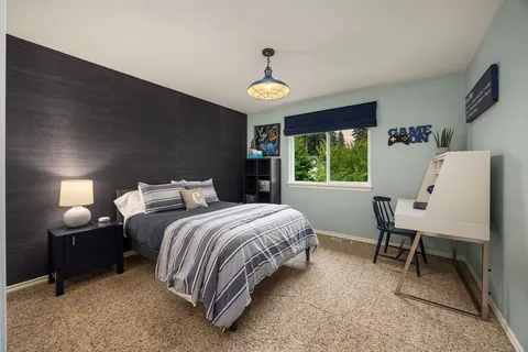 Bedroom with dark accent wall and built-in desk