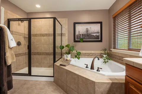 Primary bath with tiled walk-in shower and soaking tub