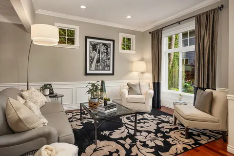 Formal living room with wainscoting and garden-facing windows