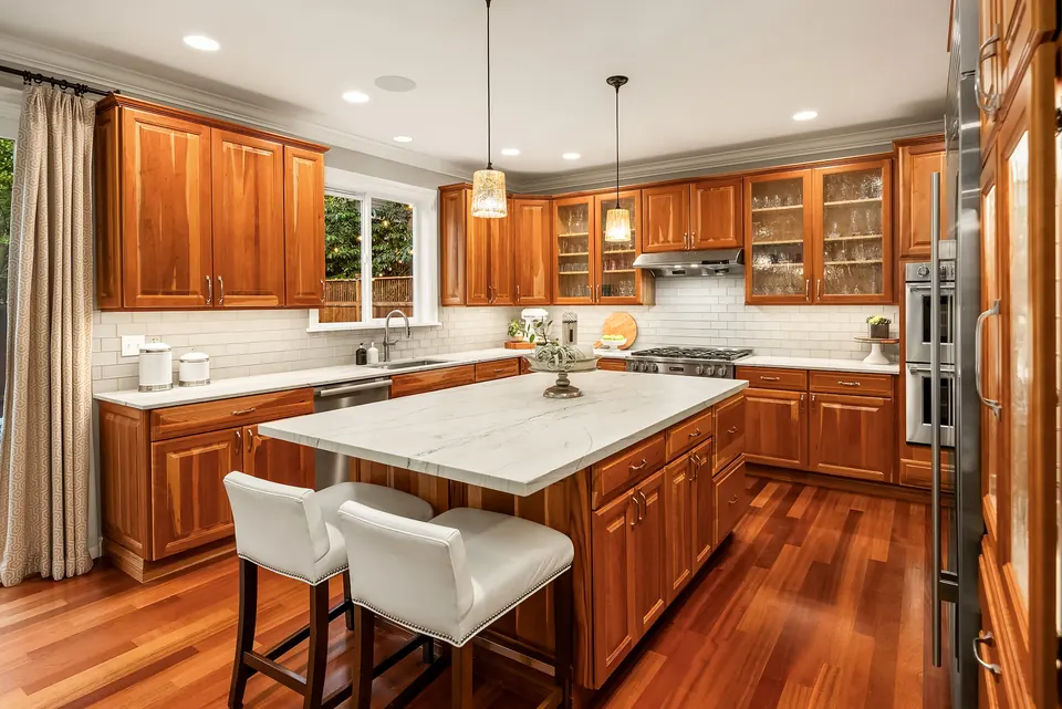 Remodeled kitchen with quartzite island, custom cabinetry, and bar seating
