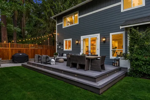 Composite deck with outdoor dining under cafe lights at dusk