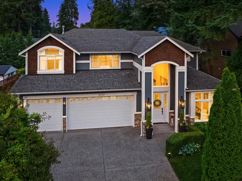 Covered front entry at dusk framed by evergreens